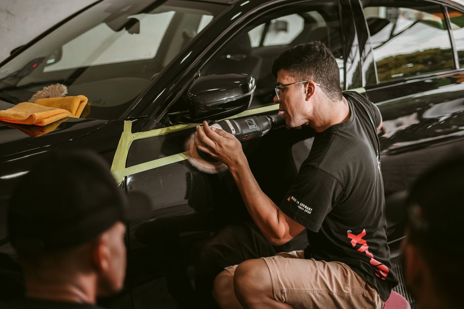 Professional auto detailer carefully polishing a car